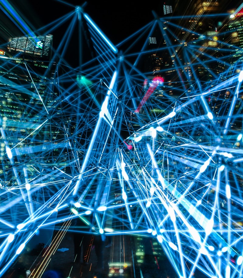 Web of neon blue lights overlaid on a cityscape