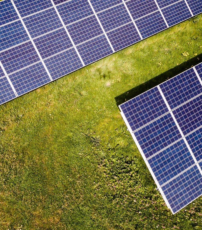 Aerial photograph of solar panels in a field of green grass